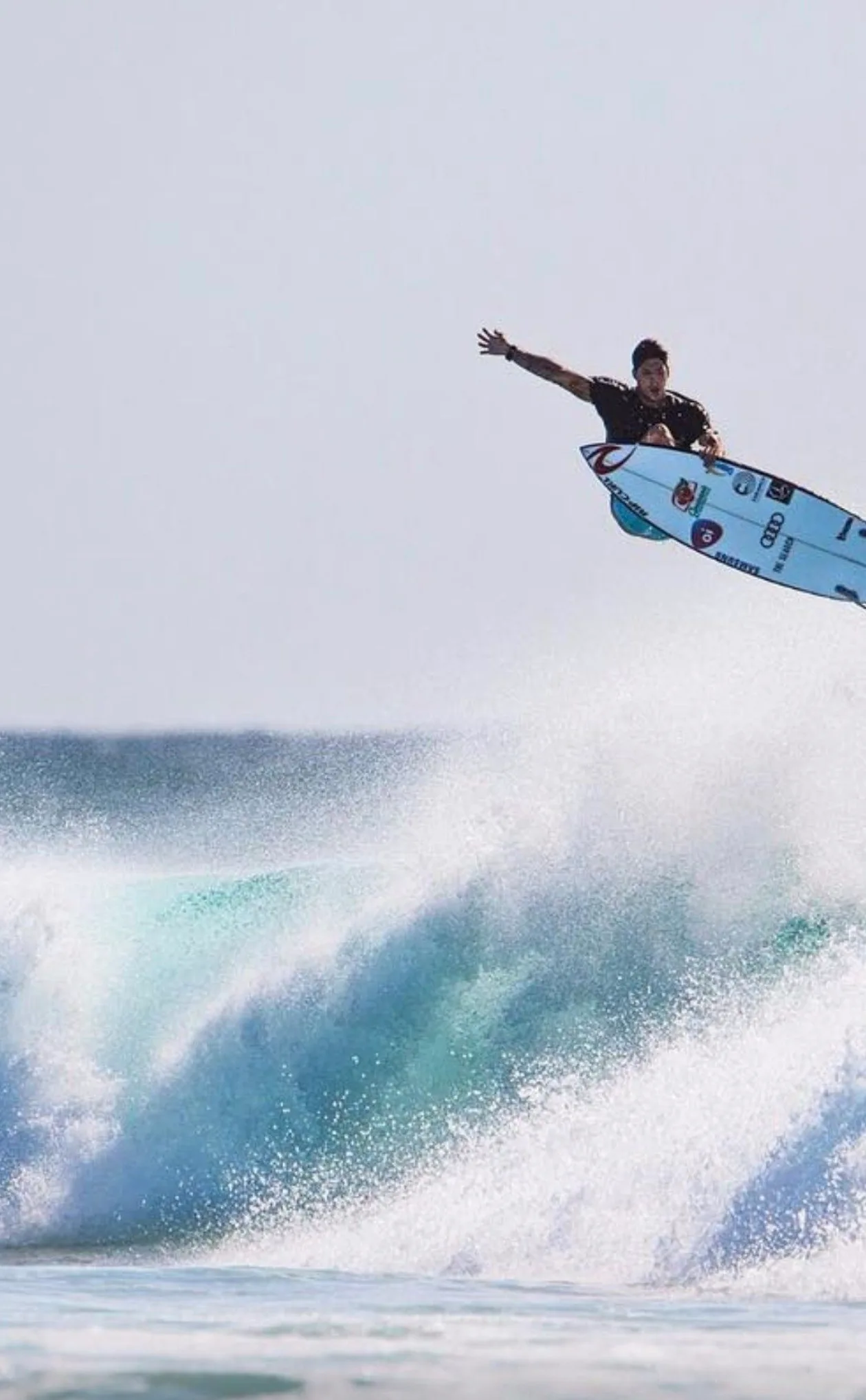 Surfer launching above a wave